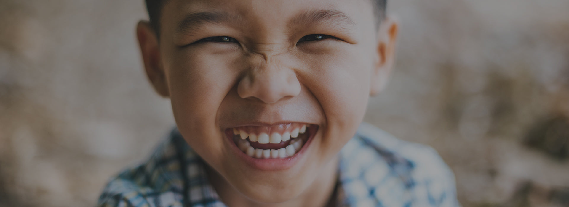 jeune enfant qui sourit en montrant ses dents