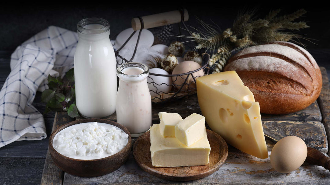 différents fromages sur une table avec du pain, du lait et des yaourts