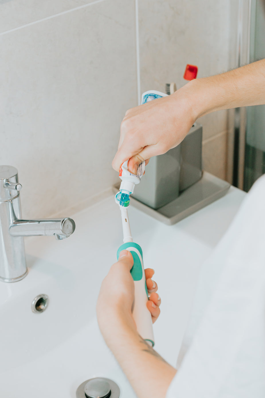 femme qui met du dentifrice sur sa brosse à dent